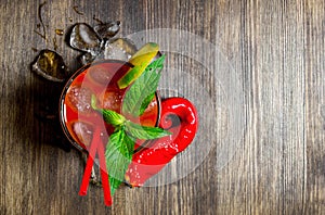 Cocktail with ice and ingredients on wooden background . Free space for text.