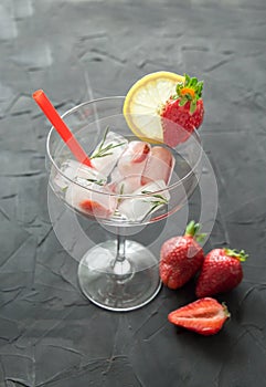 Cocktail made from Strawberries and rosemary ice cubes into the glass