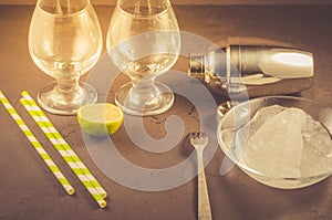 Cocktail making bar tools/Cocktail shaker, two glass lime and straws on a dark background. Selective focus