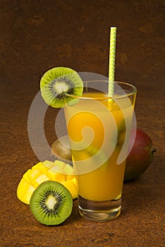 Cocktail with mango, kiwi, pineaple and rum on brown background. Selected focus.