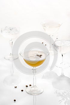 Cocktail mix in glass on white background with alcohol, coffee beans peel foam martini espresso