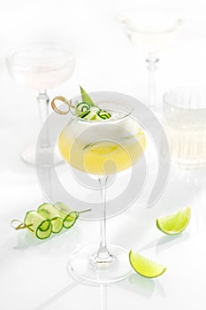 Cocktail mix in glass on white background with alcohol, cucumber, lemon and lime, cetriolo