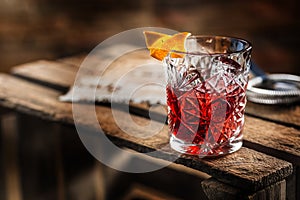 Cocktail Negroni on a old wooden board. Drink with gin, campari photo