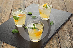 Cocktail. Orange juice with mint and ice on rustic wooden table