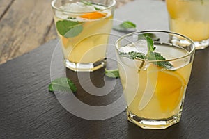 Cocktail. Orange juice with mint and ice on rustic wooden table