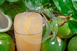Cocktail and passion fruit juice Passiflora edulis Sims and fresh green fruits on a woody background