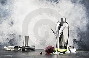 Cocktail preparation scene with bar tools and ingredients, gray bar counter background, copy space