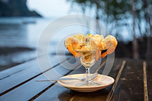 Cocktail salad with prawn and seafood on a wooden table against the background of the sea
