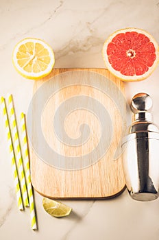 Cocktail shaker and tropical fruits/Cocktail shaker and tropical fruits on a white marble background. Top view