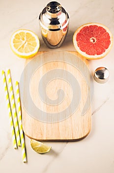 Cocktail shaker and tropical fruits/ Cocktail shaker and tropical fruits on a white marble background. Top view. Copy space