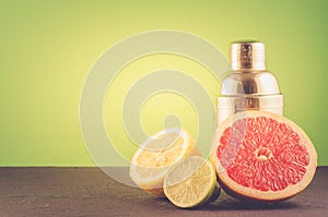 Cocktail shaker and tropical fruits on a green background/Cocktail shaker and tropical fruits on a green background. Selective