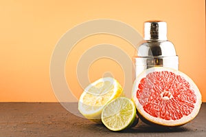 Cocktail shaker and tropical fruits on a orange background/Cocktail shaker and tropical fruits on a orange background. Selective