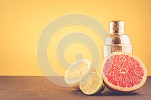 Cocktail shaker and tropical fruits on a yellow background/Cocktail shaker and tropical fruits on a yellow background. Selective