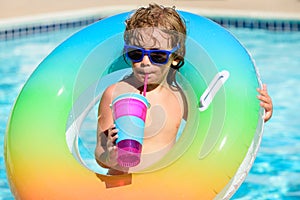 Cocktail on watter pool in the summer. Funny portrait of child. Kid having fun in swimming pool outdoors. Children with