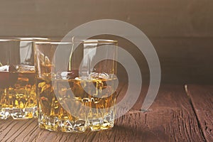 Cocktail from whisky with cherry in two glasses on a wooden back