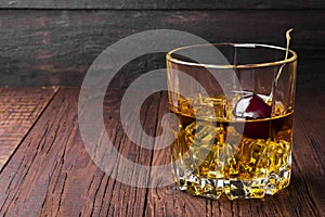 Cocktail from whisky with cherry on a wooden background. Copy sp