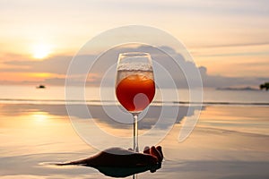 A cocktail in the wine glass over swimming pool.