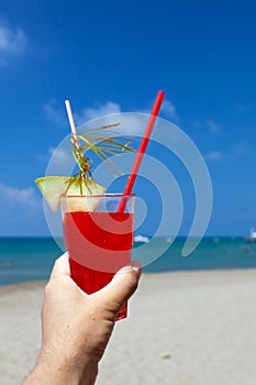 Cocktails on beach in male hand