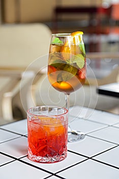 Cocktails with fruits and berries served on a white table in restaurant or bar. Alcoholic beverage