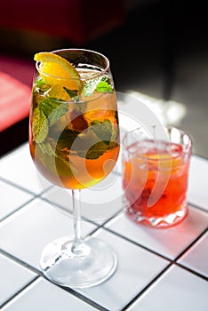 Cocktails with fruits and berries served on a white table in restaurant or bar. Alcoholic beverage