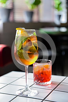 Cocktails with fruits and berries served on a white table in restaurant or bar. Alcoholic beverage