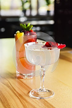 Cocktails with fruits and berries served on a wooden table in restaurant or bar. Alcoholic beverage