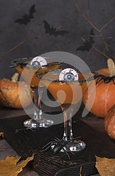 Cocktails Pumpkintini of pumpkin and martini with black sugar rim and as eyes in glass for Halloween parties