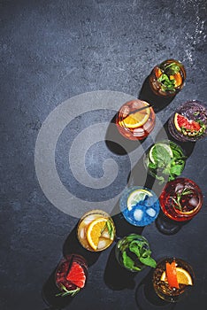 Cocktails set on black bar counter, top view. Mixology concept. Assortment of colorful strong and low alcohol drinks for cocktail