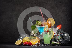 Cocktails set , disco balls mirror balls and fruits on dark gray background. Nightclub. Weekend or holiday party