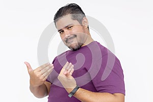 A cocky man points to himself bragging while looking smug. Wearing a purple waffle shirt. Half body photo isolated on white