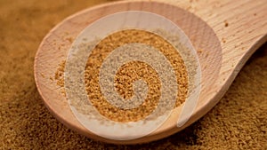 Coco brown sugar made from the kithul palm (Caryota urens) falling on a wooden spoon