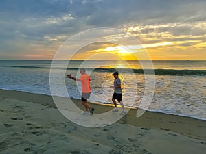 Cocoa beach, Florida, USA - April 29, 2018: Men running on the beach at sunset. Florida, USA