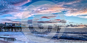 Cocoa Beach Pier at sunrise with blue and pink sky