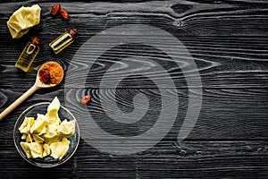 Cocoa butter as ingredient for natural cosmetics. Dark wooden background top view copy space