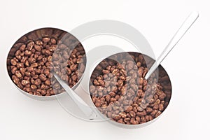 Cocoa coated puffed rice in metal bowls isolated