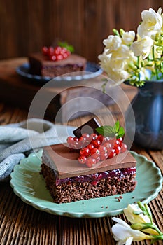 Cocoa dessert with red currant filling, topped with chocolate mousse and fresh berries
