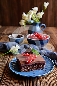 Cocoa dessert with red currant filling, topped with chocolate mousse and fresh berries