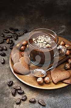 Cocoa drink in glass mug and ginger cookies on dark background