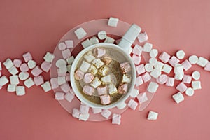 Cocoa drink with marshmallows isolated onpink or coral background, top view. Christmas hot drink