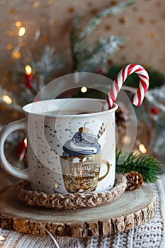 Cocoa mug on wooden stand and knitted sweater