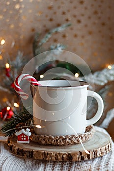 Cocoa mug on wooden stand and knitted sweater