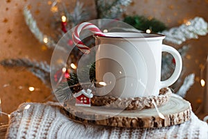 Cocoa mug on wooden stand and knitted sweater