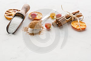 Cocoa powder in a spoon with cinnamon and dry sitrus. A high key.