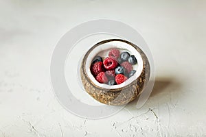 Coconut bowl with fresh berries for healthy vegetarian diet breakfast