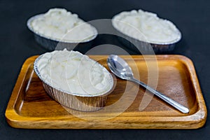 Coconut cake with coconut topping on wooden plate