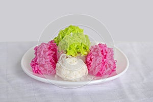 Coconut candy balls coated sugar or Maprao Keaw in white plate is Traditional Thai dessert.