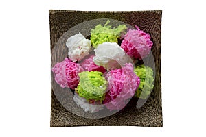 Coconut candy balls coated sugar or Maprao Keaw in wooden plate is Traditional Thai dessert isolated on white background.