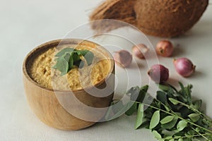 Coconut chutney. Spicy condiment made of fresh coconuts, red chilies and shallots. Served in a wooden bowl. An accompaniment for