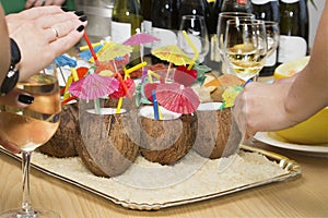 Coconut cocktail with colorful straws and colored paper palm tr