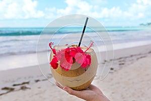 Coconut cocktail in a woman`s hand